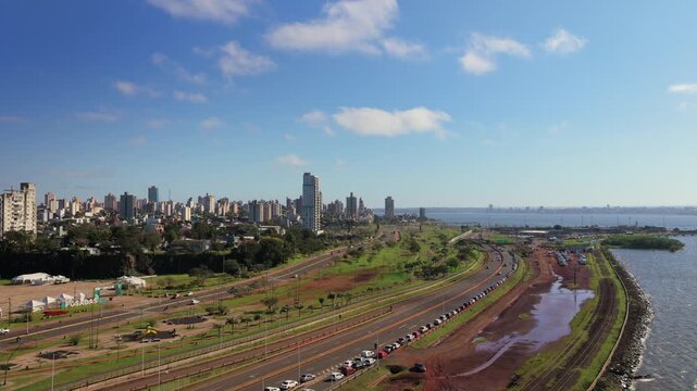 Wide aerial view reveals vehicles lining the international border corridor beside the city of Posadas.