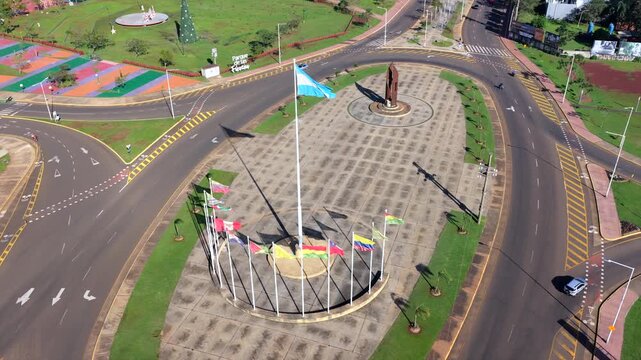 Aerial view circling a public display of South American national flags in an urban setting.