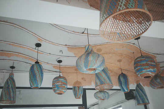 Unique handmade woven rattan pendant lamps hanging from a textured ceiling in a modern interior