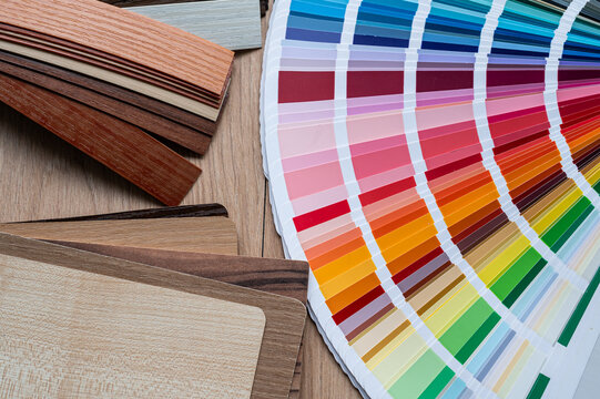 Top View of Wooden Laminate Swatches and Paint Palette Guide for Furniture Production Workspace