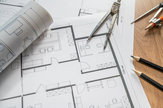 Architectural Blueprint Floor Plan with Drafting Compasses and Pencils on Wooden Table Desk