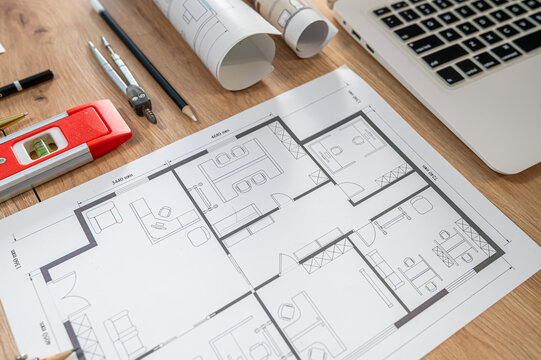 Flat Lay Top View of House Blueprint Draft with Laptop Red Spirit Level and Drafting Compasses