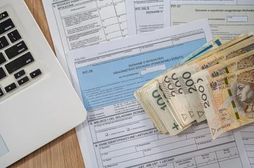 Close up of Polish PIT Declaration Documents with Pen and Zloty Cash Stack for Tax Refund Day © RomanR