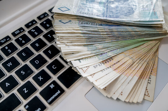 Stack of Polish Zloty Banknotes on White Laptop Keyboard for E Commerce and Online Earnings