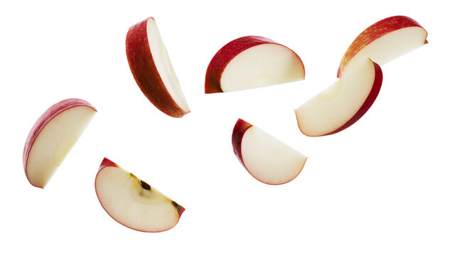 Fresh red apple slices falling in midair