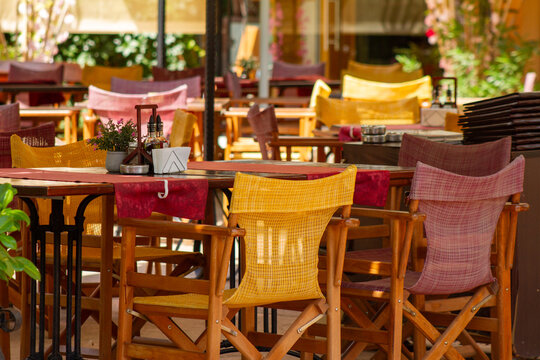 Cozy Outdoor Restaurant Terrace with Colorful Woven Director Chairs, Wide Shot