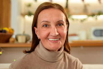 Fototapeta premium Happy Caucasian Middle Aged Woman Smiling at Home During Christmas Holiday Celebration