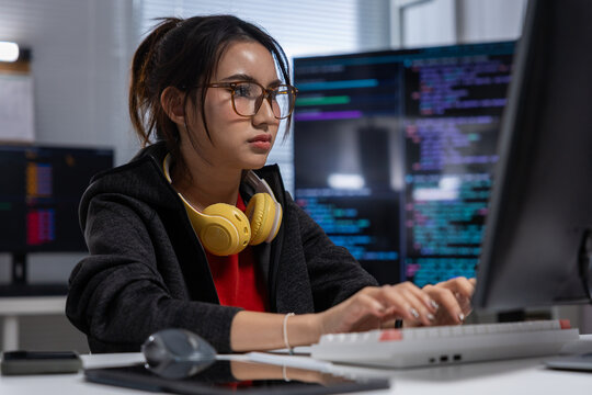 Young woman programmer computer laptop coding technology office focused expression