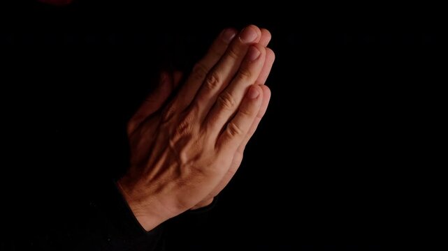 Hands Pressed Together in Prayer Against Black Background, Expressing Faith Reflection and Spirituality