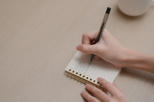 Personal finance and household budgeting concept. Close up of hands writing expense plans. wallet and credit cards, managing monthly spending at home. budgeting, expenses, finance, savings, planning