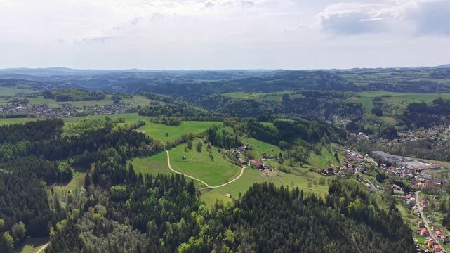 Aerial view of a rural landscape no action observed static aerial view, in rural countryside with rolling hills and scattered buildings, with hills, buildings, vegetation, with green, brown accents.