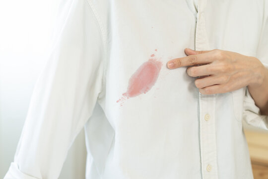 Dirty sauce stain cloth, asian young woman, girl wearing white shirt showing making on her cloth stain, spot dirty or smudge on clothes for cleaning before washing, maid female working at home concept