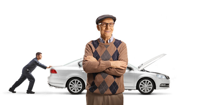 Senior man standing with arms crossed as a mechanic pushes his broken down car