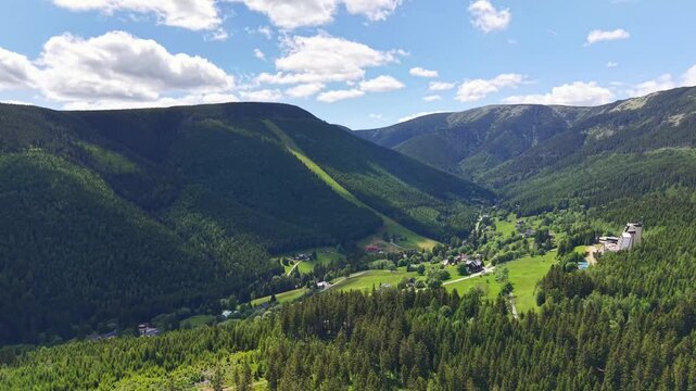 Mountain landscape static scene, in outdoor natural environment, with mountains, trees, from a wide-angle aerial perspective perspective, with green, blue accents, and serene and peaceful mood.