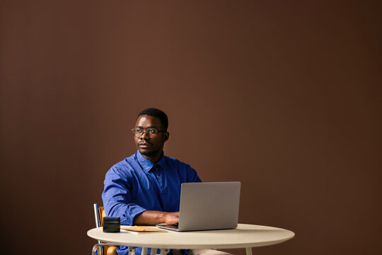 Businessman Working Thoughtfully On Laptop At Table