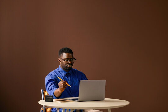 Focused Man Working on Laptop at Desk