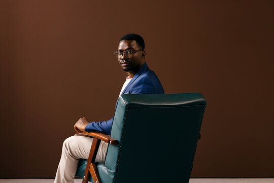 Confident Businessman in Blue Sitting in Leather Chair