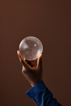 Hand Holding Textured Glass Bowl On Brown Background