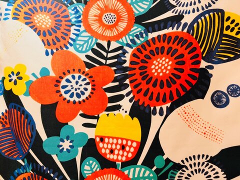 Vibrant canvas fabric featuring a bold floral and botanical pattern with red, orange, teal, yellow, black, and white elements.