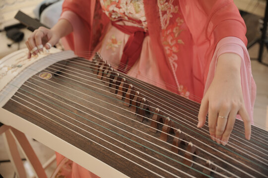 Woman playing a traditional Indonesian string instrument, highlighting cultural music, artistic performance, and the preservation of traditional musical heritage.