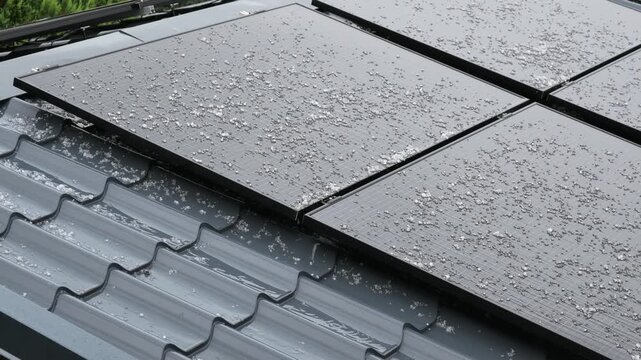 hailstones falling on rooftop solar panels during severe summer storm and extreme weather
