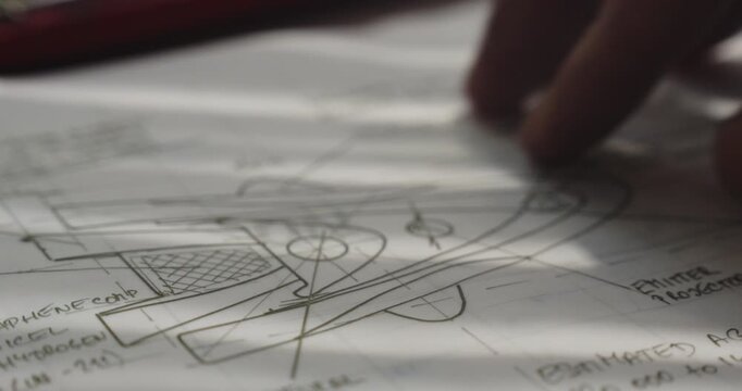 Morning sunlight creates soft striped shadows across spaceship design blueprint plans, creating a futuristic engineering and aerospace design concept.