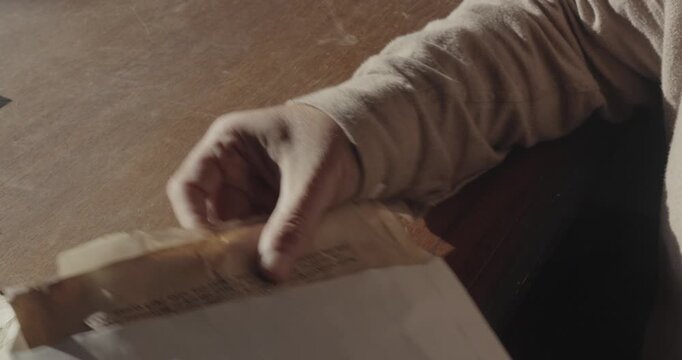 Staged investigator scene showing an envelope opened and aged, crumpled documents arranged across office desktop as confidential case papers.