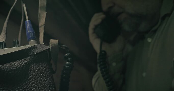 Man communicates command messages using old radio equipment inside a dark wartime bunker, creating a cinematic scene of military communication.