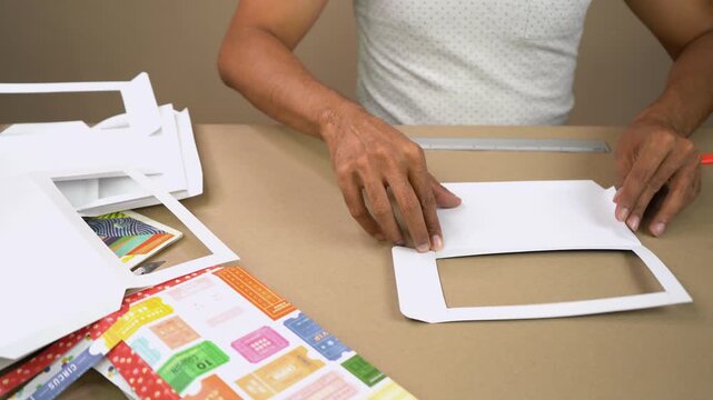 Close up view of hands carefully folding paper to create handmade window envelope