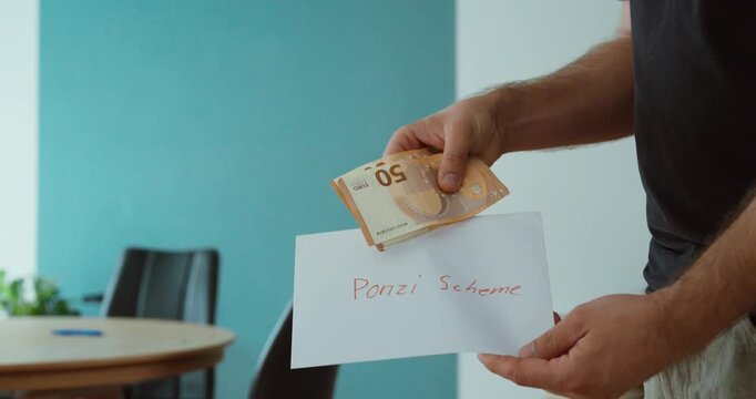 Person holding euro banknotes with a Ponzi scheme sign, representing investment fraud, financial scams, pyramid schemes and deceptive money making.