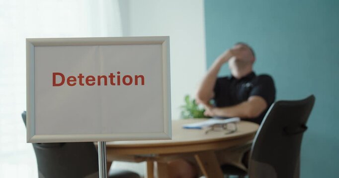 Person sitting in detention with a frustrated posture, representing school punishment, disciplinary action, consequences, misconduct and student behavior.
