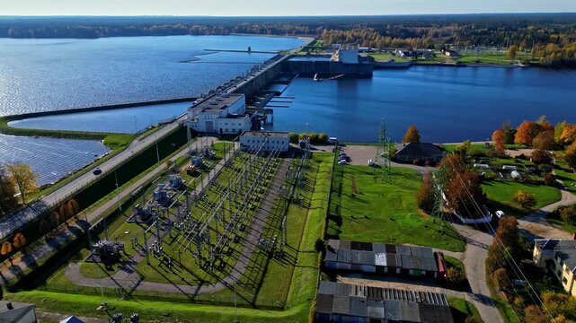Aerial view of the Keguma Hydroelectric Power Station on the Daugava River, featuring the dam, power plant infrastructure, and surrounding green landscape in Kegums, Ogres novads, Latvia.
