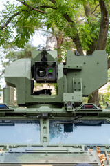 Obraz premium Heavy machine gun on top of a green camouflage colored armored vehicle