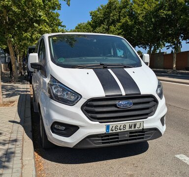 Vista frontal de una furgoneta Ford Transit Custom con acabado Sport y cap&oacute; con doble franja negra vertical, aparcada en una calle de Madrid, Espa&ntilde;a, 16 de junio de 2026
