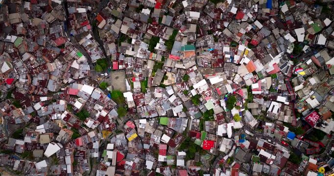 Dense tin roofs and brick houses in Comuna 13 in Medellin, Colombia. Aerial top-down forward