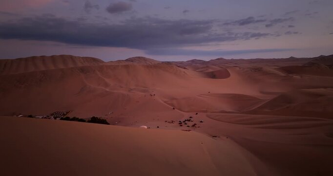 Desert sand dunes in Huacachina at dusk in Ica, Peru. Aerial drone panoramic view