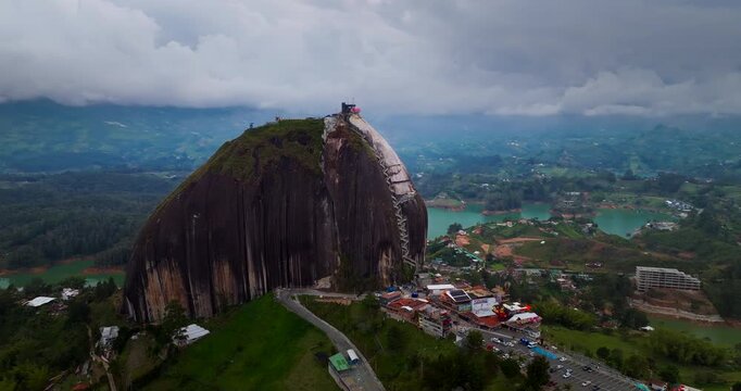Cinematic 4K drone orbit of La Piedra del Pe&ntilde;ol monolith over Guatap&eacute; reservoir, Medell&iacute;n area, Colombia, iconic travel landmark