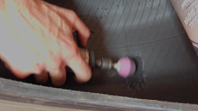 A slow motion close up in 4K UHD shows a rotary sanding tool smoothing the punctured area on a tire before patch repair