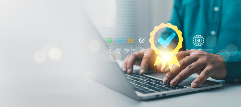 Professional using a laptop with quality certification and digital checkmarks, representing compliance, quality assurance, business standards, document verification, auditing, and process management.