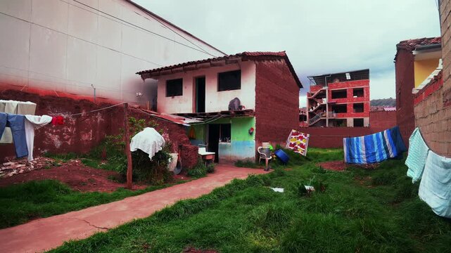Cusco City of Cuzco mi casa local Peruvian neighborhood home building structure Peru landscape drying laundry clothes backyards green grass Anta Province Sacred Valley rainy season cloudy morning pan
