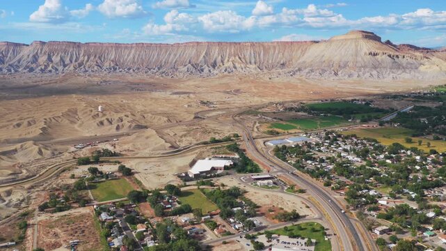 Downtown Grand Junction Book Cliffs Mesa Clifton aerial drone Colorado afternoon cloudy Grand Mesa Colorado River summer sunny blue sky Parachute Fruita Mt Garfield businesses cars i70 backwards pan