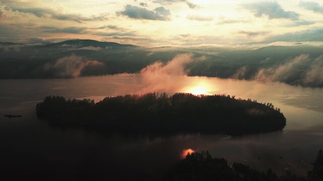 Aerial drone harbor view sunset Lake Schroon Clarks Island summer golden hour mist low clouds Up State New York landscape Town of Schroon Lake Pharaoh Mtn Adirondack Mountains circle left