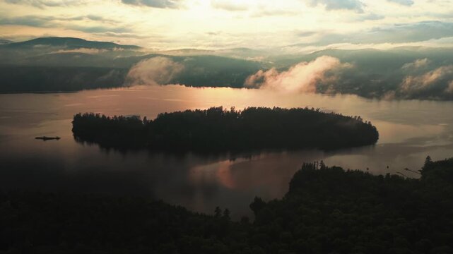 Sunset Lake Schroon Clarks Island aerial drone summer golden hour mist low clouds harbor view Up State New York landscape Town of Schroon Lake Pharaoh Mtn silhouette Adirondack Mountains backwards up