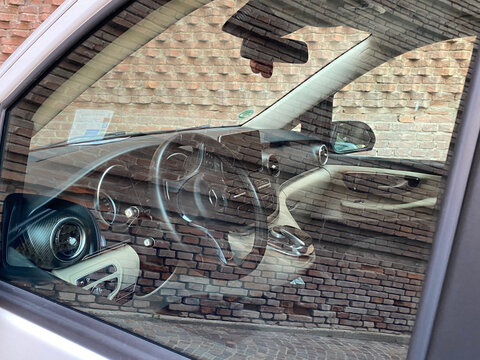 Mercedes Benz V Class luxury van interior with dashboard and steering wheel reflecting a brick wall