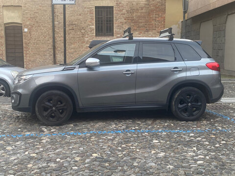 Suzuki Vitara compact crossover SUV parked on a cobblestone street, ready for urban or adventure travel