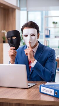 Masked businessman signaling silence beside an accounts binder