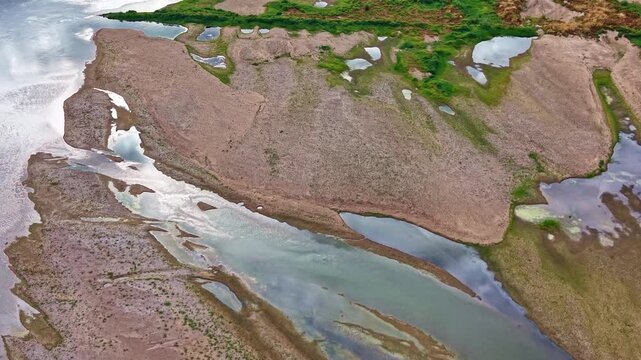 Loire River at extreme low water reveals exposed alluvial bars, shallow channels and residual pools, showing drought stressed river morphology in France, drone flyover