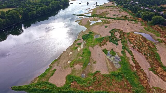 Loire River at very low water reveals extensive alluvial bars, branching shallow channels, exposed sediment and vegetation across broad floodplain near Angers, Maine et Loire, France, forward aerial