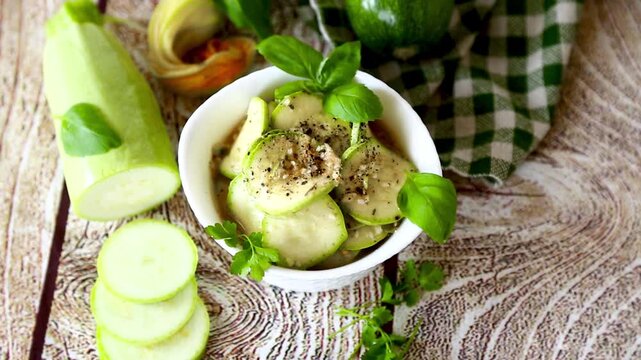 Fresh zucchini appetizer with garlic herbs on light wood background