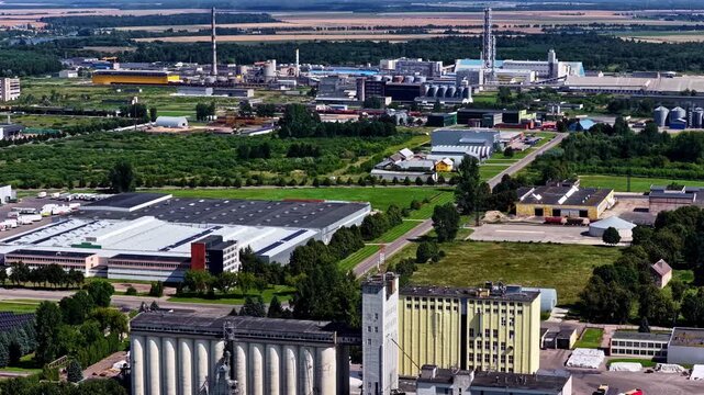 Phosphate fertilizer plant urrounded by industrial buildings, near solar fields, aerial establishing overview